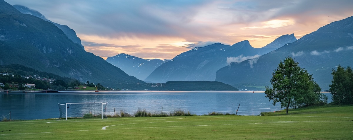 Norwegischer Fußballplatz am Fjord im Flutlicht