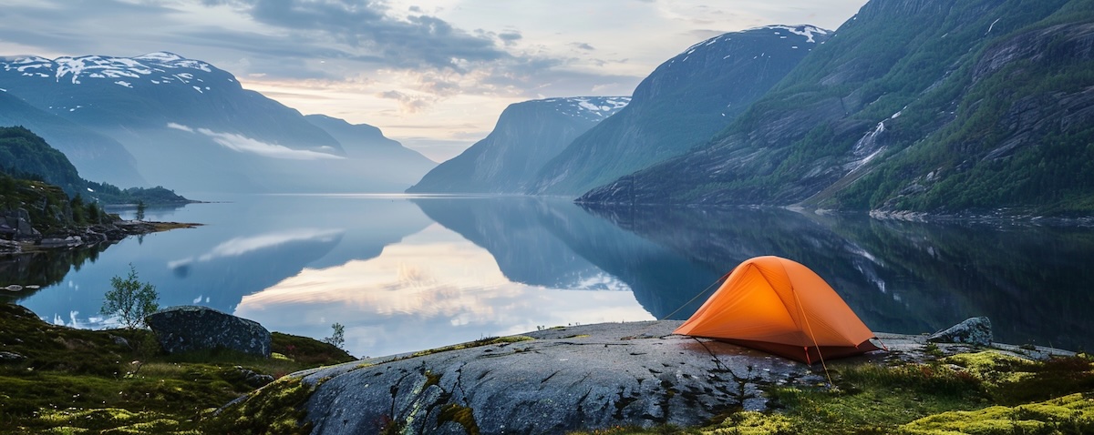 Zelt über einem norwegischen Fjord im Morgenlicht