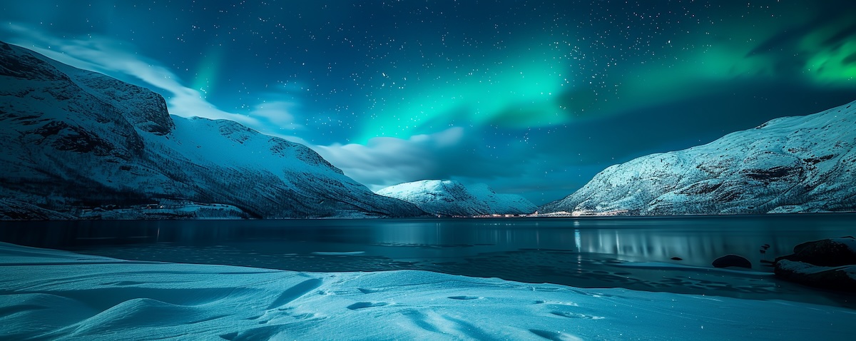 Winterlandschaft in Norwegen mit Nordlicht über verschneitem Fjord